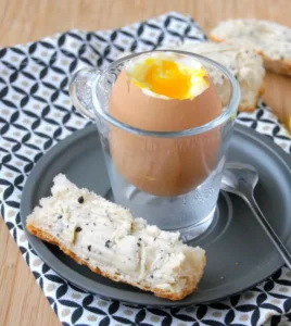 Oeuf à la coque et mouillettes de beurre de truffe noire